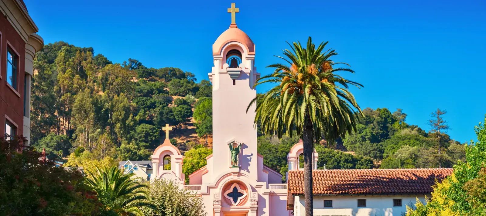 The bell tower of Mission San Rafael Arcángel among palm trees